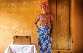 Maman Danga Esambo steht vor einer Wand. Sie ist Mutter von sieben Kindern. Zusammen mit anderen Frauen hat sie eine Solidaritätsgruppe gegründet.