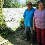 Zwei Begünstigte aus einem Projekt in Kolumbien zeigen zufrieden ihren Garten.
