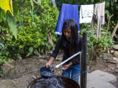 Ein Guatemalteke holt Wasser aus einer geschützten Wasserquelle - Wasser in Guatemala sichern